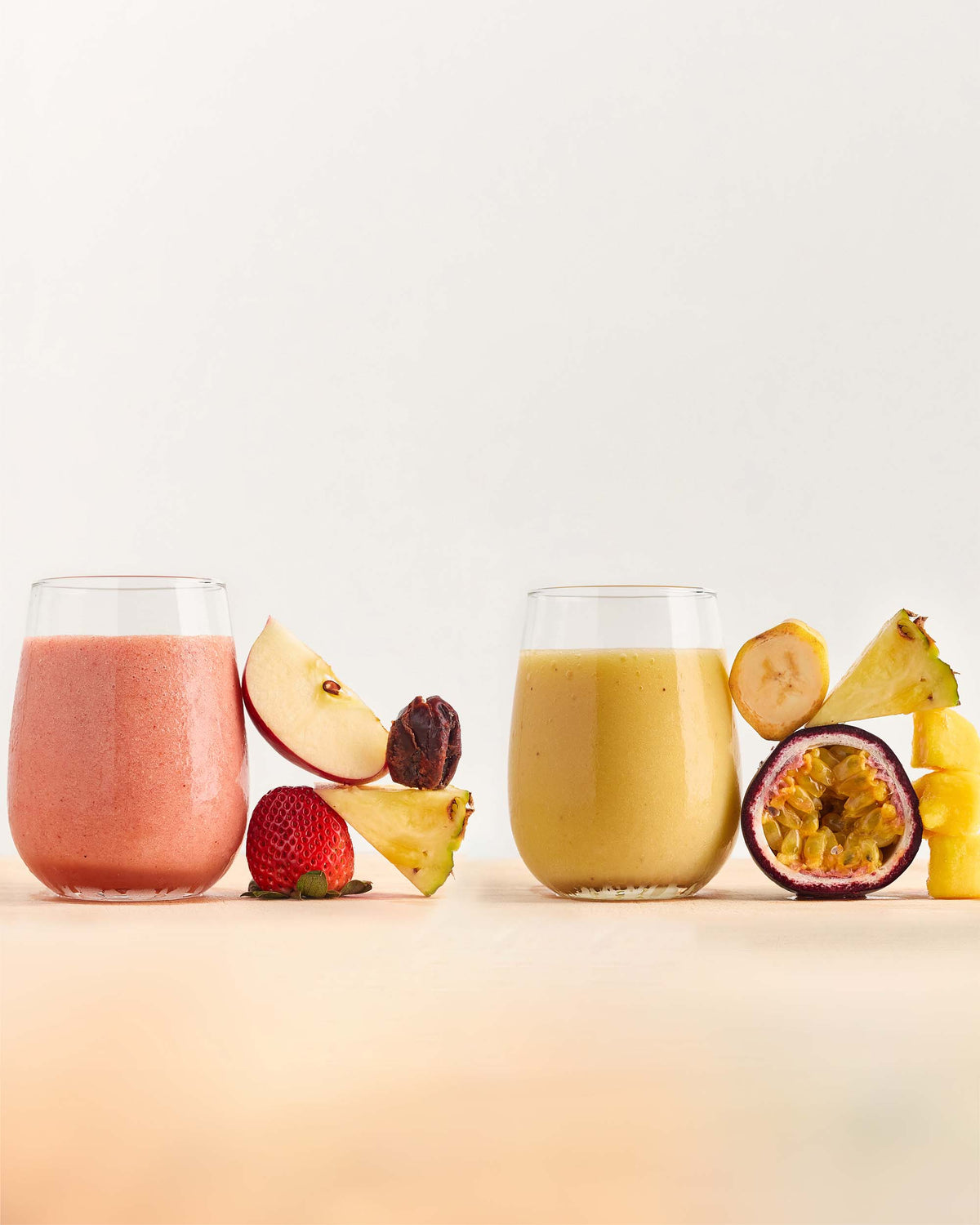 Colourful healthy smoothies with fruit ingredients next to the glass