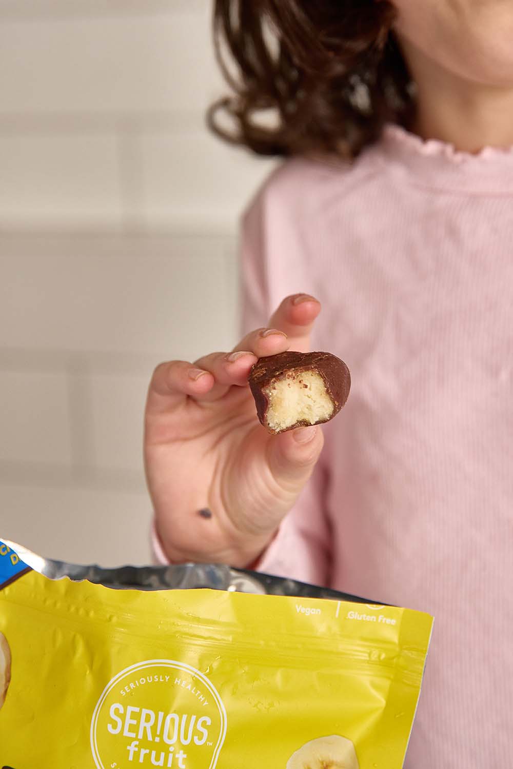 Child holding frozen banana bite in hand
